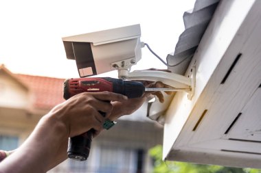 Teknisyen su veya yağmurdan cctv koruma için su geçirmez beyaz plastik kutu ile el tornavida ile kablosuz Cctv güvenlik kamerası yükleme.