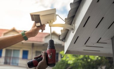 Teknisyen su veya yağmurdan cctv koruma için su geçirmez beyaz plastik kutu ile el tornavida ile kablosuz Cctv güvenlik kamerası yükleme.