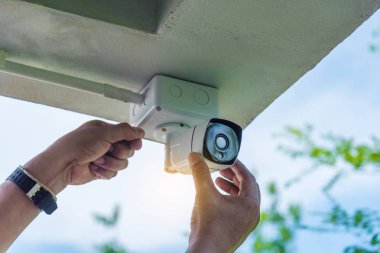 Teknisyen su veya yağmurdan cctv koruma için su geçirmez beyaz plastik kutu ile el tornavida ile kablosuz Cctv güvenlik kamerası yükleme.