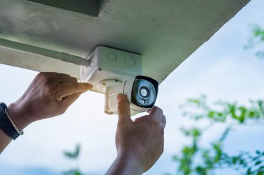 Teknisyen su veya yağmurdan cctv koruma için su geçirmez beyaz plastik kutu ile el tornavida ile kablosuz Cctv güvenlik kamerası yükleme.
