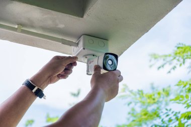 Teknisyen su veya yağmurdan cctv koruma için su geçirmez beyaz plastik kutu ile el tornavida ile kablosuz Cctv güvenlik kamerası yükleme.