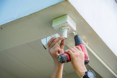 Teknisyen su veya yağmurdan cctv koruma için su geçirmez beyaz plastik kutu ile el tornavida ile kablosuz Cctv güvenlik kamerası yükleme.