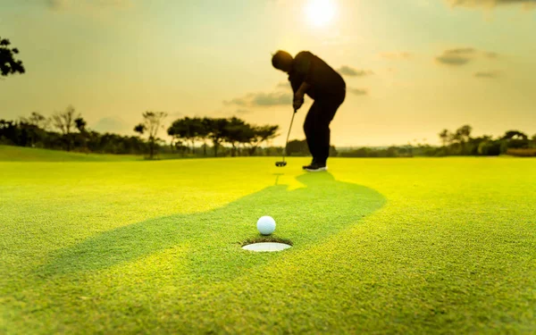 轮廓高尔夫球手在比赛中表现出快乐 白色高尔夫球在绿草的高尔夫球场上有着模糊的背景 — 图库照片