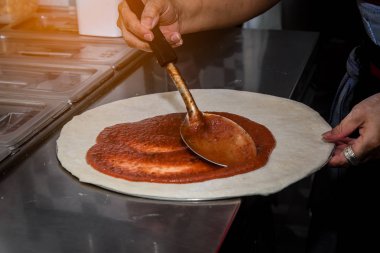 Şefin kapalı eli mutfak restoranında peynirli pizza yapma süreci..