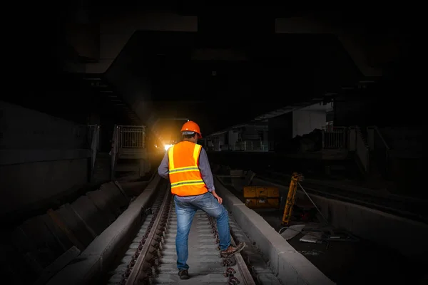 engineer under inspection and checking construction process railway switch and checking work on railroad station .Engineer used radio communication and safety helmet in work.