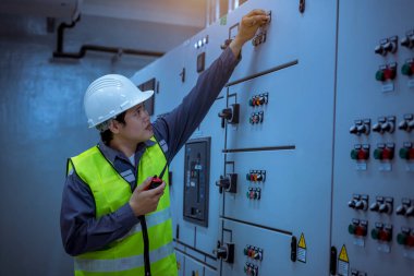 Mühendis, Ana Dağıtım Tahta Fabrikası 'nda çalışan voltaj aralığını kontrol etmek için elektrik santraliyle çalışıyor..