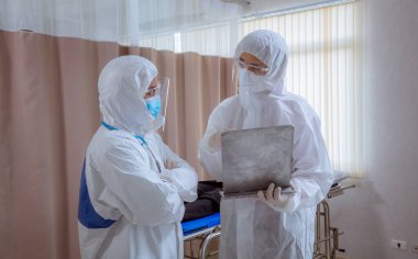 Koronavirüslerden korunmak ve hastalara bakmak için güvenlik üniforması ve tıbbi maske takan profesyonel doktor ekibi. .