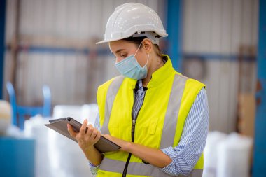 Portre çalışanları, fabrikadaki kirliliği ve virüsü korumak için güvenlik maskesi takarak istasyonda inceleme ve üretim maskesi üretim sürecini kontrol ediyorlar.