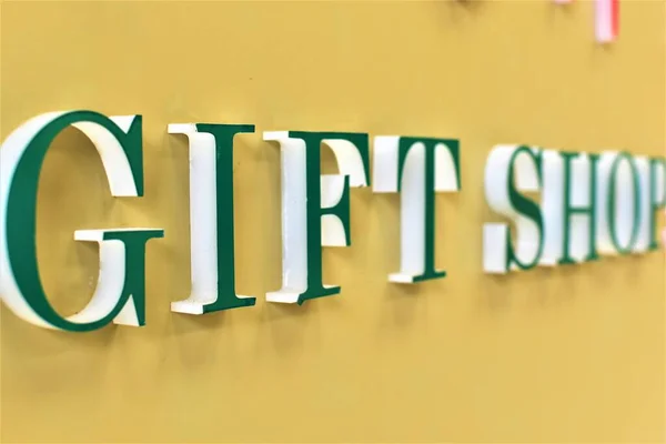Green Bold Giftshop Signage Yellow Wall — Stock Photo, Image