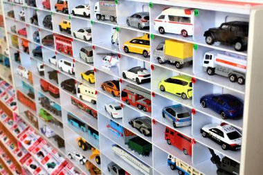 Diecast model cars are displayed for sale on a shelf in a toy store clipart