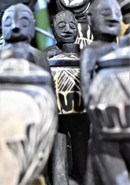 Kavanoz tutan yerli ahşap heykeller.