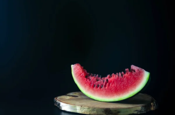 In Scheiben geschnittene saftige reife Wassermelone auf dunklem Hintergrund für das Menü — Stockfoto