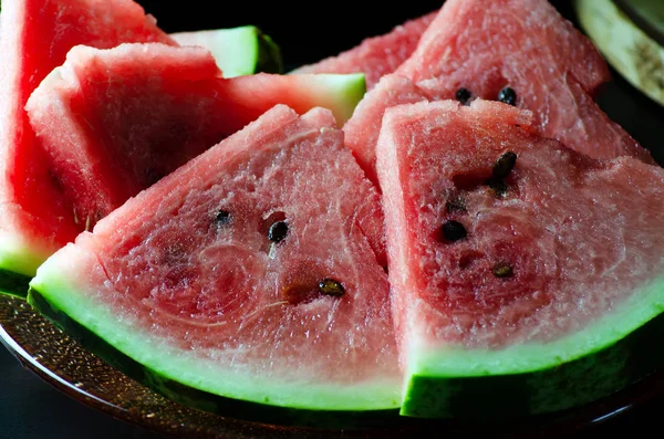 In Scheiben geschnittene saftige reife Wassermelone auf dunklem Hintergrund für das Menü — Stockfoto