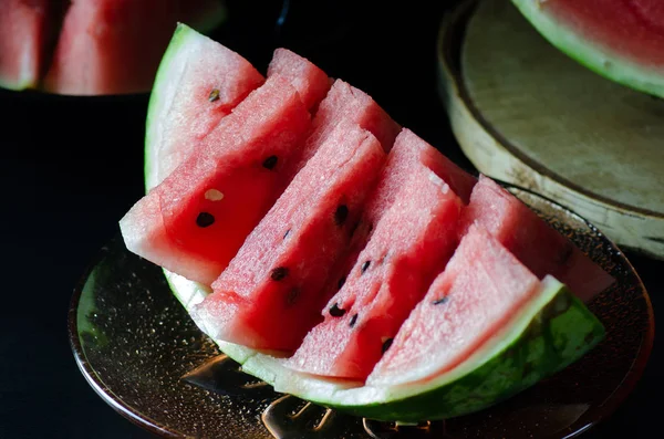 In Scheiben geschnittene saftige reife Wassermelone auf dunklem Hintergrund für das Menü — Stockfoto