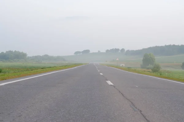 Pusta droga we wczesnym rannym mgle — Zdjęcie stockowe