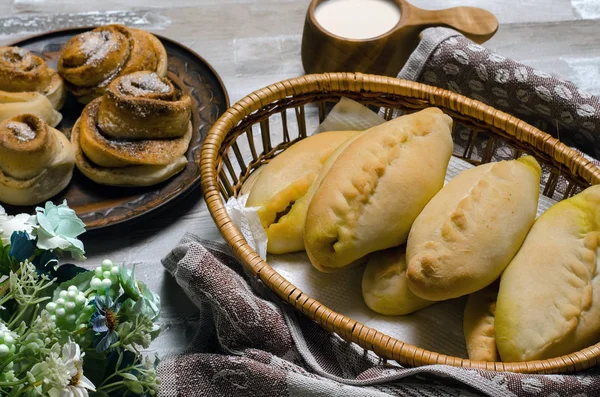 homemade baked pasties with cabbage and sweet buns with sugar and cinnamon