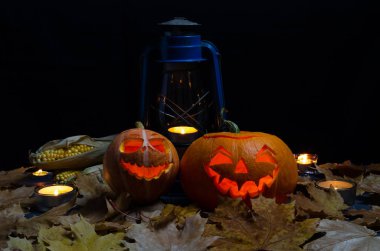 Sonbahar yaprakları ve mısır ile karanlık bir arka plan üzerinde bir el lambası ve mumlar fener ile Halloween kabak baş jack