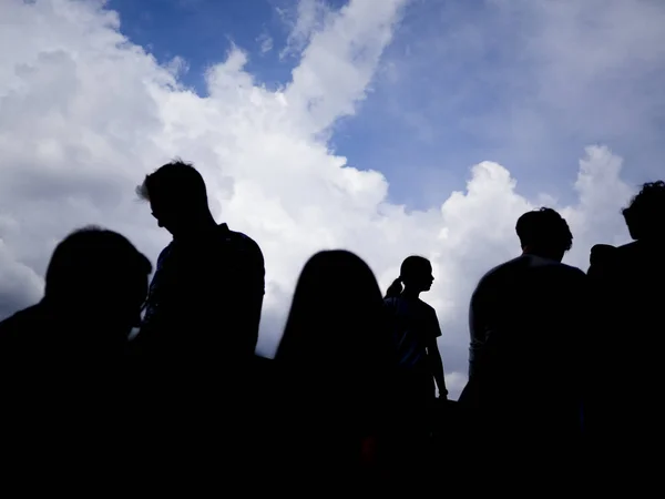 Uma silhueta de um grupo de pessoas com no fundo — Fotografia de Stock