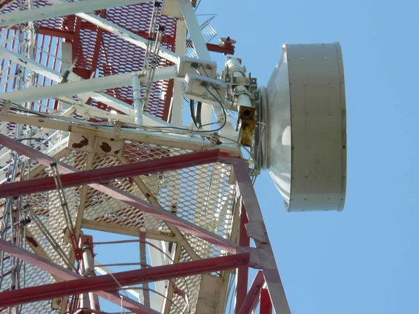 Cell Tower and Radio link Station microwave on the background of the blue sky. Aerial view of telecommunications tower inspection for cell phone, radio transmitters.
