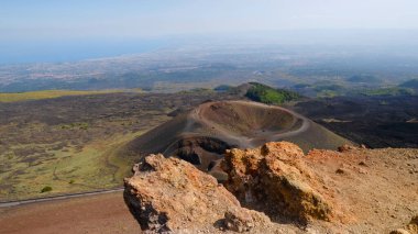 Büyük, pas rengi kayalar, kül konisi ve volkanik kraterle engebeli volkanik manzara. Volkanik bölgenin güçlü güzelliği, Etna Dağı 'nın eşsiz çevresi. Seyahat, doğa, jeoloji.