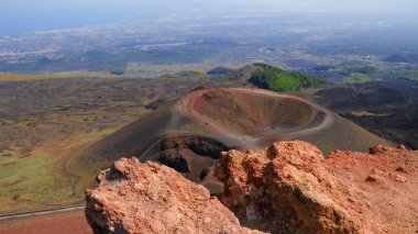 Büyük, pas rengi kayalar, kül konisi ve volkanik kraterle engebeli volkanik manzara. Volkanik bölgenin güçlü güzelliği, Etna Dağı 'nın eşsiz çevresi. Seyahat, doğa, jeoloji.
