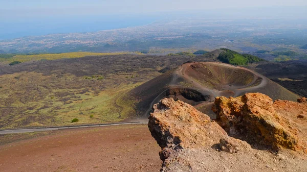 Büyük, pas rengi kayalar, kül konisi ve volkanik kraterle engebeli volkanik manzara. Volkanik bölgenin güçlü güzelliği, Etna Dağı 'nın eşsiz çevresi. Seyahat, doğa, jeoloji.