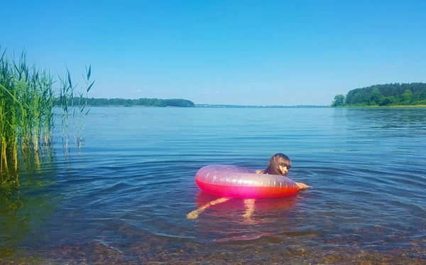 girl 6-7 years old swimming in the lake