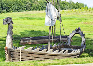 Eski terk edilmiş balıkçı teknesi nehir kenarındaki yeşil çimlerde.