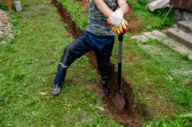 İşçi su için çukur kazıyor.