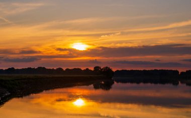 Nehir ve çayırların sabah manzarası sisli