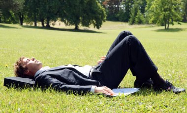 Öğle yemeği freni sırasında dinlenen işadamı dışarıda bir parkta dinleniyor
