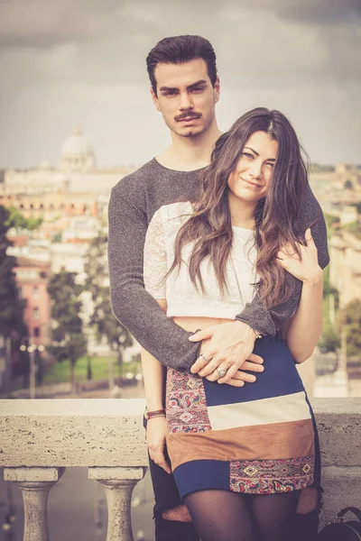 在罗马度假美丽可爱的意大利年轻夫妇拥抱在户外 一对年轻夫妇在意大利罗马市中心的一个露台上拥抱在一起 — 图库照片