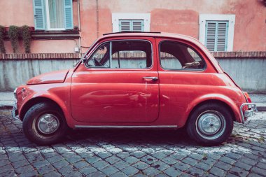 Eski İtalyan arabası Fiat 500 Cinquecento İtalya 'nın tarihi merkezine park edilmiştir. Turuncu renk, kaldırım taşlarıyla döşenmiş..