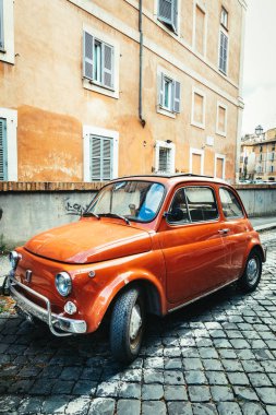 Roma, İtalya. 10 Haziran 2020: Eski İtalyan arabası Fiat 500 Cinquecento İtalya 'nın tarihi merkezine park edilmiştir. Turuncu renk, kaldırım taşlarıyla döşenmiş..