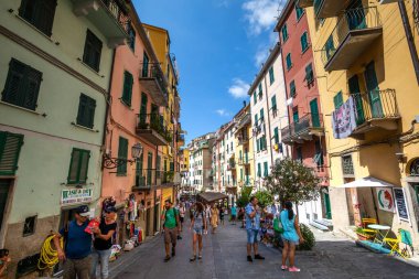Riomaggiore, İtalya. 15 Ağustos 2020: İtalya 'nın Riomaggiore şehrinde turist ve renkli binaların olduğu cadde. Sokaktaki ticari faaliyetler.