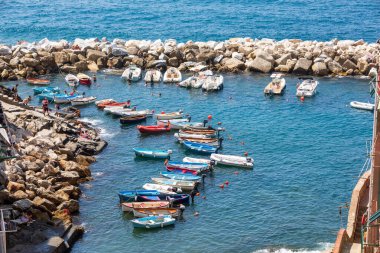 Riomaggiore, İtalya. 15 Ağustos 2020 'de İtalya' da Riomaggiore Denizi 'nde kayalıklı ve kayalıklı bir limanda. Tatilcilerden bazıları. Mavi deniz.