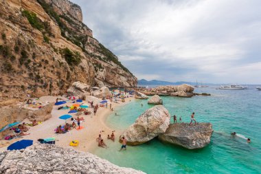 Cala Mariolu, Sardinya. 3 Ağustos 2020 'de İtalya' da Sardinya 'da doğal bir koyda sahil. Yaz boyunca çok sayıda insan tatilde. Rocky sahili manzarası.