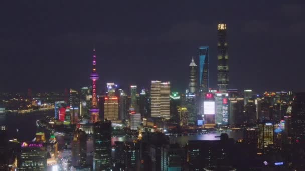 ШАНХАЙ, Китай - 20 марта 2018 года: Shimao International Plaza и Lujiazui Skyline в ночное время. Шанхай, Китай. Вид с воздуха. Беспилотники летают боком и вверх — стоковое видео