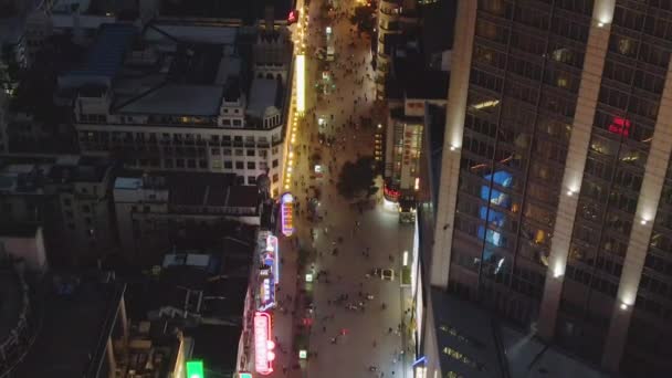 Gente en Nanjing Road por la noche. Calle peatonal en el distrito de Huangpu. Ciudad de Shanghai, China. Vista aérea. Drone vuela hacia adelante — Vídeo de stock