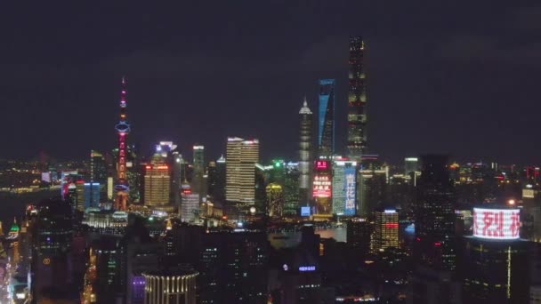 Shimao International Plaza en Lujiazui skyline 's nachts. Shanghai City, China. Luchtfoto. Drone vliegt opzij en omhoog — Stockvideo