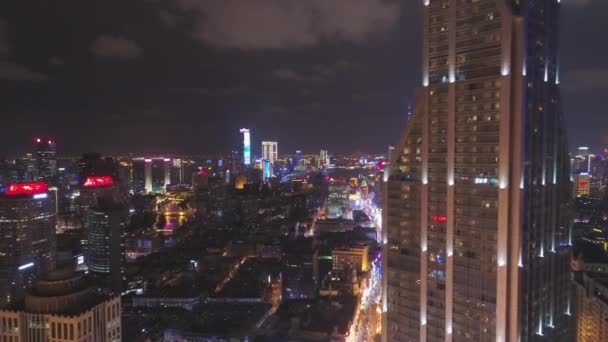 SHANGHAI, CHINA - 20 DE MARZO DE 2018: Shimao International Plaza y Lujiazui Skyline por la noche. Vista aérea. Drone vuela hacia los lados y hacia arriba — Vídeo de stock