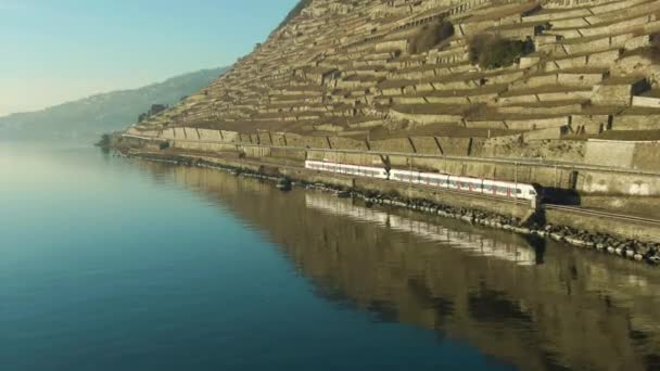 Tren de pasajeros va a lo largo del lago Geneva Shore. Reflexión en el agua. Vista aérea — Vídeos de Stock