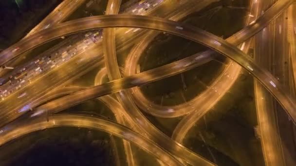 Intersección de carreteras y tráfico de coches por la noche. Sobrevolando. Vista aérea de arriba hacia abajo — Vídeo de stock