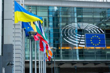 BRÜKSEL, BELGIUM - 16 Haziran 2025: Brüksel, Belçika 'daki Espace Leopold Kompleksi' ndeki Altiero Spinelli binasının Avrupa Parlamentosu Logosu ve Avrupa Birliği Bayrakları