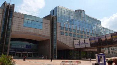 BRÜKSEL, BELGIUM - 16 Haziran 2025: Avrupa Birliği 'nin Brüksel' deki Espace Leopold Avrupa Parlamentosu Binası Esplanade Panosu, Belçika Illustrating Challenches of European Union. Geçip giden insanlar