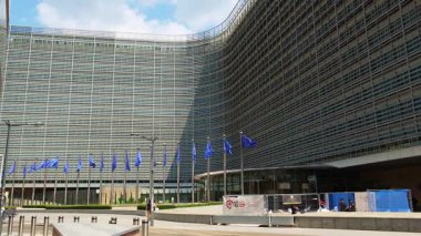 BRÜKSEL, BELGIUM - 16 Haziran 2025: Berlaymont Binası, Avrupa Komisyonu Genel Merkezi ve Avrupa Birliği Bayrakları. Brüksel, Belçika 'da. Yavaş Hareket