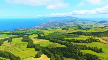 Pastureland ile yemyeşil tepeler. Atlantik Okyanusu. Gölgeleri Bulutlardan Çekmek. Azores, Sao Miguel Adası. Portekiz. Hava görüntüsü. Drone Yanlamasına Hareket Ediyor