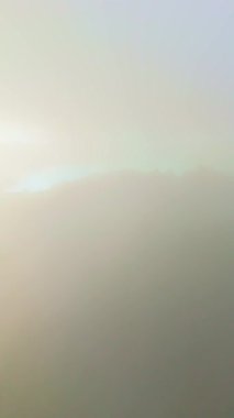 Sunset 'te Sete Cidades Caldera. Blue Lake ve Santiago Gölü. Azores, Sao Miguel Adası. Bulutlar ve Sis. Portekiz. Hava görüntüsü. Drone Ağaçların Üzerinde İleri ve Yukarı İlerliyor. Şutu göster. Dikey Video