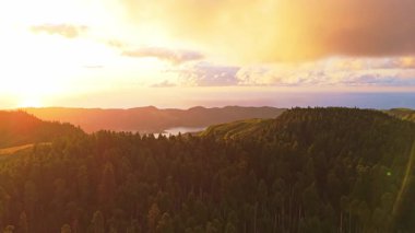 Sunset 'te Sete Cidades Caldera. Blue Lake ve Santiago Gölü. Azores, Sao Miguel Adası. Portekiz. Hava görüntüsü. Drone Ağaçların Üzerinde İleri ve Yukarı İlerliyor. Görüntü Görüntüsü