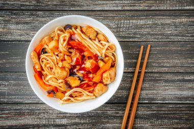 tatlı ve ekşi sos ve chopsticks ahşap masa, üstten görünüm üzerinde Udon erişte. Geleneksel Asya mutfağı
